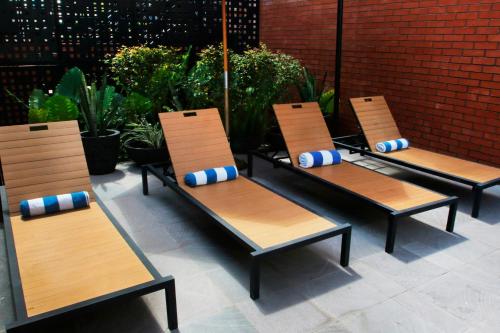 four chairs with blue and white pillows sitting on a patio at City Express Plus by Marriott Tampico in Tampico