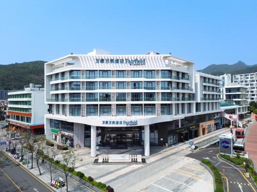 a large white building in the middle of a city at Fairfield by Marriott Shenzhen Dameisha in Shenzhen