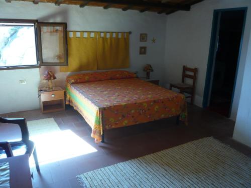 ラ・マッダレーナにあるCasa Vacanze Abbatoggiaのベッドルーム1室(ベッド1台、椅子、窓付)