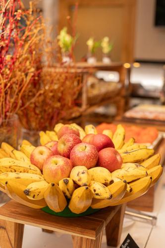 a bowl of bananas and apples on a table at Hotel BH Palace in Belo Horizonte