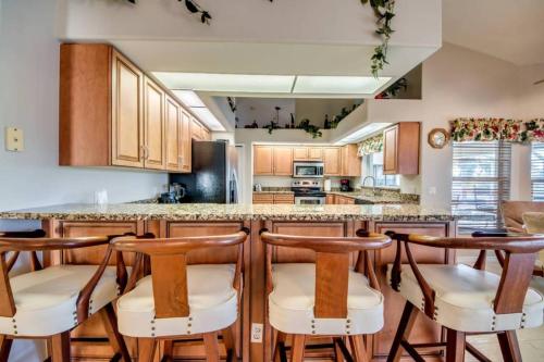 une cuisine avec des placards en bois et des tabourets de bar dans l'établissement Stunning Villa Coret, à Ramatuelle