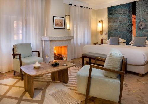 una camera d'albergo con letto e camino di Les Jardins De La Médina a Marrakech