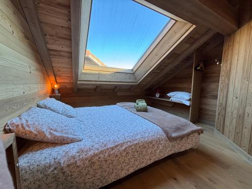 a bedroom with a large window in an attic at Lumen Wood in La Bresse
