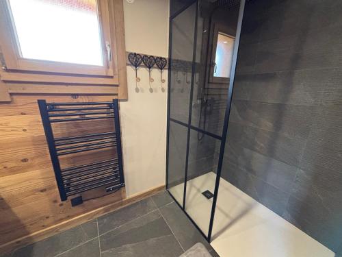 a glass shower in a bathroom with a window at Lumen Wood in La Bresse