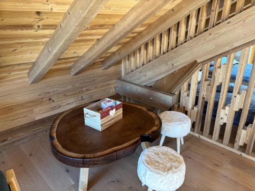 a room with a wooden table and stool in a cabin at Lumen Wood in La Bresse
