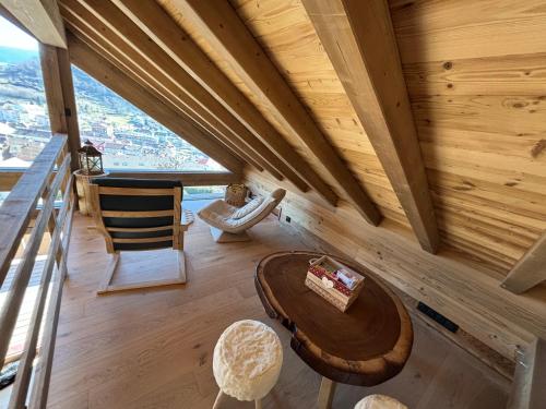 a room with a wooden ceiling with a table and chairs at Lumen Wood in La Bresse