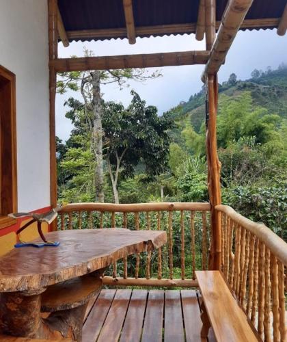 a wooden porch with a wooden table on a deck at Cabaña El Otoño in Pijao