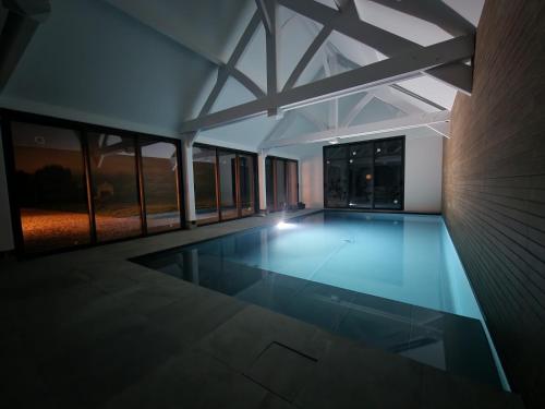 - une piscine vide dans une maison avec fenêtres dans l'établissement Cottage du Golfe - 2 logements - 18 personnes, à Plescop