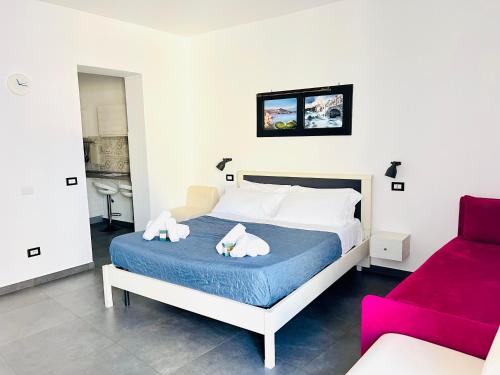 a bedroom with a bed and a red couch at "Sweet Life" Casa Vacanze in Lipari