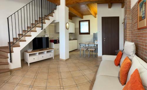 a living room with a couch and a tv and a kitchen at Il Ghiandolino in Imola