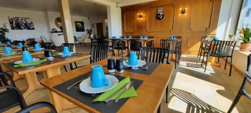 a restaurant with wooden tables and chairs with blue napkins at " NEW 2025 " Plein Vent 800m entrée Combes circuit Spa Francorchamps in Francorchamps