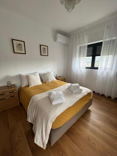 a bedroom with a large bed and a window at Casa de Fráguas in Arouca