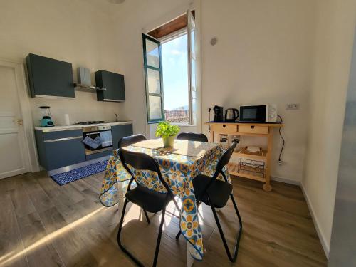 Una cocina y un comedor con mesa y sillas. en Casa Bonita Guest House, en Salerno