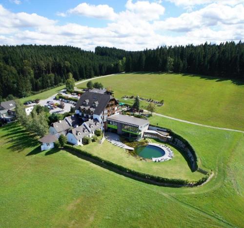 eine Luftansicht eines großen Hauses auf einem Feld in der Unterkunft Hotel Schwarz Alm Zwettl in Zwettl Stadt