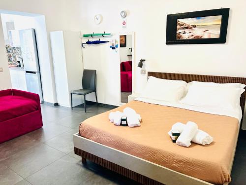 a bedroom with a bed and a red chair at "Sweet Life" Casa Vacanze in Lipari