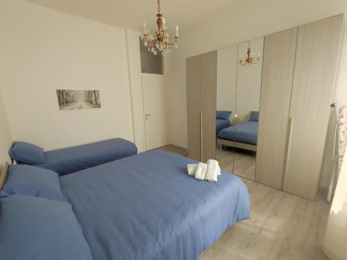 a bedroom with two blue beds and a mirror at Villa Antonella app Lavinia in Tavernerio