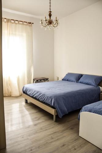 a bedroom with two beds and a chandelier at Villa Antonella app Lavinia in Tavernerio