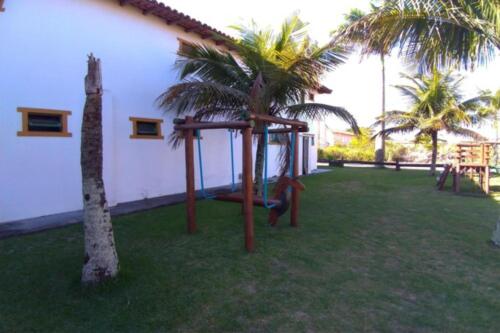 a playground in the yard of a house with palm trees at OYO Pousada do Wagner, Rio das Ostras in Rio das Ostras