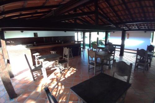 a dining room with tables and chairs in a building at OYO Pousada do Wagner, Rio das Ostras in Rio das Ostras
