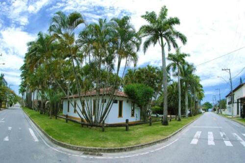 a house on the side of a street with palm trees at OYO Pousada do Wagner, Rio das Ostras in Rio das Ostras