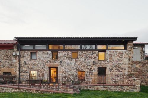 duży kamienny budynek z czarnym dachem w obiekcie Hotel Rural Las Encinas w mieście Santa María de Redondo