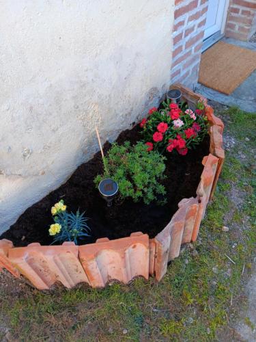 a brick garden with flowers and plants in it at Maison de la plage in Marcilly-sur-Seine