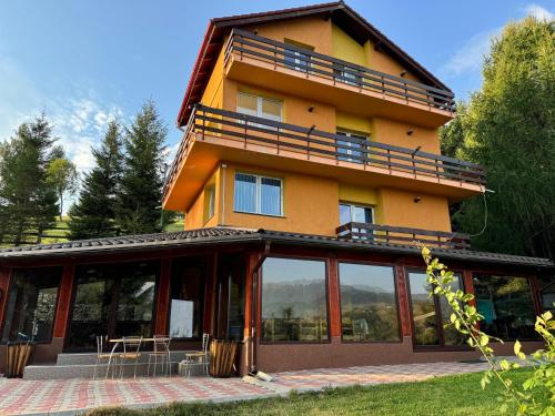 a large building with glass doors and windows at Vila Serar in Moieciu de Jos