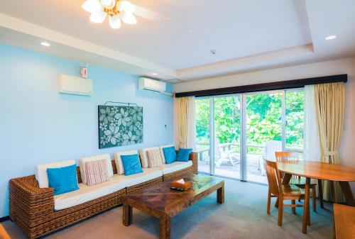 a living room with a couch and a table at Scallop Beach Condominium in Onna