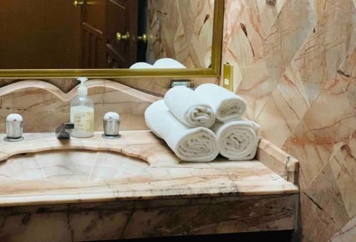a bathroom with a sink with towels and a mirror at Casa Lomas en Zona Dorada, 5 minutos de la playa in Mazatlán