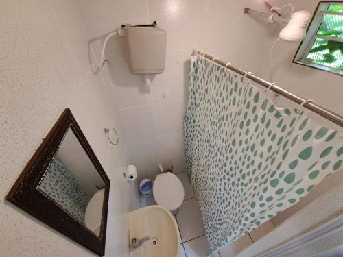 Un baño con espejo y un inodoro. en Casinha da Galera na Ilha do Mel!, en Paranaguá