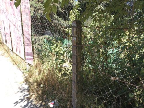 a chain link fence next to a field of grass at Mindfulness Glamping, Retiro de Yoga, Todo Incluido in Mexico City