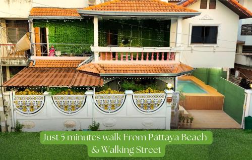 a house with a fence with flowers on it at Bigg Villa at Walking Street in Pattaya South