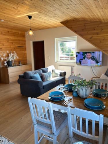 a living room with a table with chairs and a couch at I - caly apartament z dużym tarasem Warmia Kids&chill raj dla dzieci in Gietrzwałd