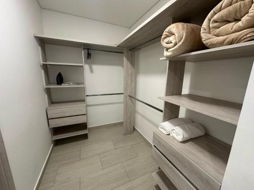 un vestidor con estanterías de madera y toallas en Amara201-Hermoso Apartamento comodo y amplio en Laureles, en Armenia