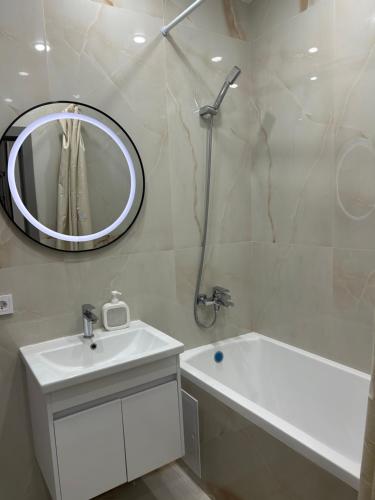 un bagno bianco con lavandino e specchio di Апартаменты в ЖК Атлант a Kökşetaw