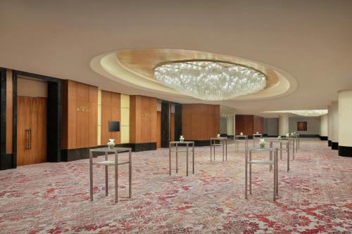 a large room with a chandelier and tables in it at The Ritz-Carlton Jakarta, Pacific Place in Jakarta
