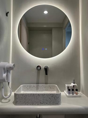 a bathroom with a sink with a round mirror at Marjay Boutique in Parikia