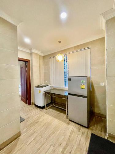 a kitchen with a refrigerator and a table in it at DL Homestay in Phnom Penh