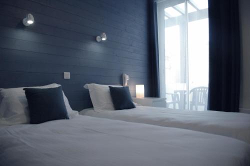 a bedroom with two beds and a blue wall at La Pergola d'Arcachon in Arcachon