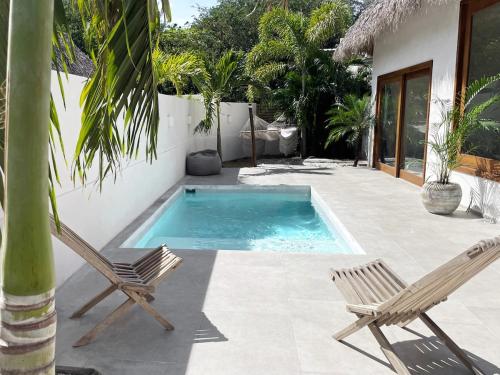 a patio with two chairs and a swimming pool at Mahalo Villa Selva with Private Pool in Popoyo