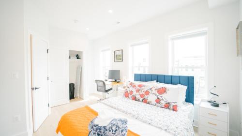 a white bedroom with a bed and a desk at Stylish 4BR Home Near Columbia Heights & Rooftop in Washington, D.C.