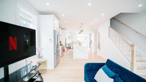 a living room with a blue couch and a tv at Stylish 4BR Home Near Columbia Heights & Rooftop in Washington, D.C.