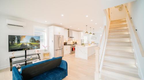 a living room with a blue couch and a staircase at Stylish 4BR Home Near Columbia Heights & Rooftop in Washington, D.C.