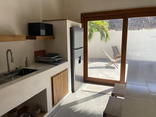 a kitchen with a refrigerator and a sliding glass door at Mahalo Villa Selva with Private Pool in Popoyo
