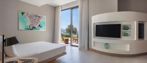 a white room with a bed and a tv at Susona Bodrum, LXR Hotels & Resorts in Torba