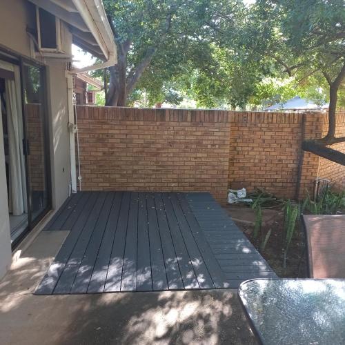 a patio in front of a brick wall at Cronin Luxury accommodation Room 4 in Kimberley