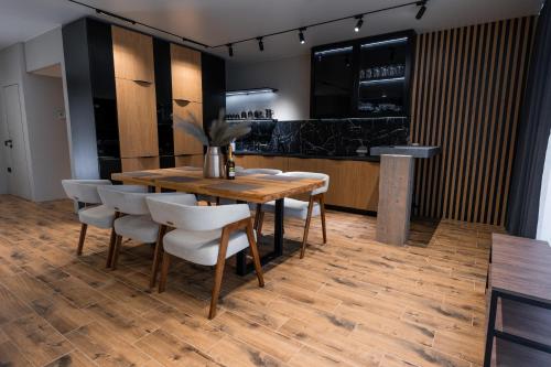 Un comedor con una mesa de madera y sillas blancas. en GOLDHILL villa 10, en Yaremche
