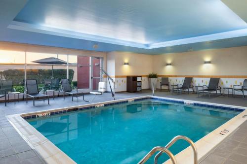 a pool in a hotel room with chairs and tables at Fairfield Inn & Suites by Marriott Columbus Dublin in Dublin
