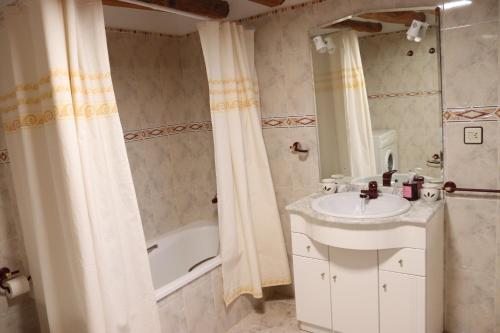 un bagno con lavandino e vasca da bagno di La Torreta a Gerbe