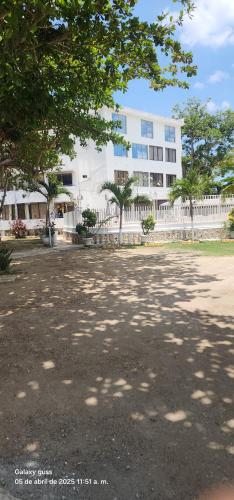 a large white building with trees in front of it at Condominio, Cabaña 202 in Puerto Viejo